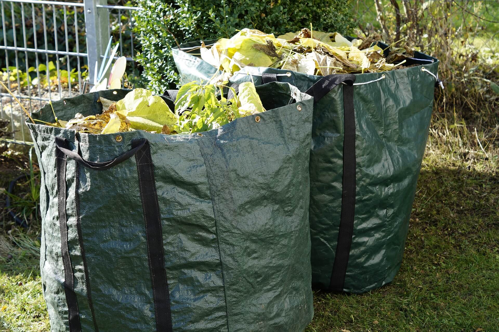 two large green bags of garden waste