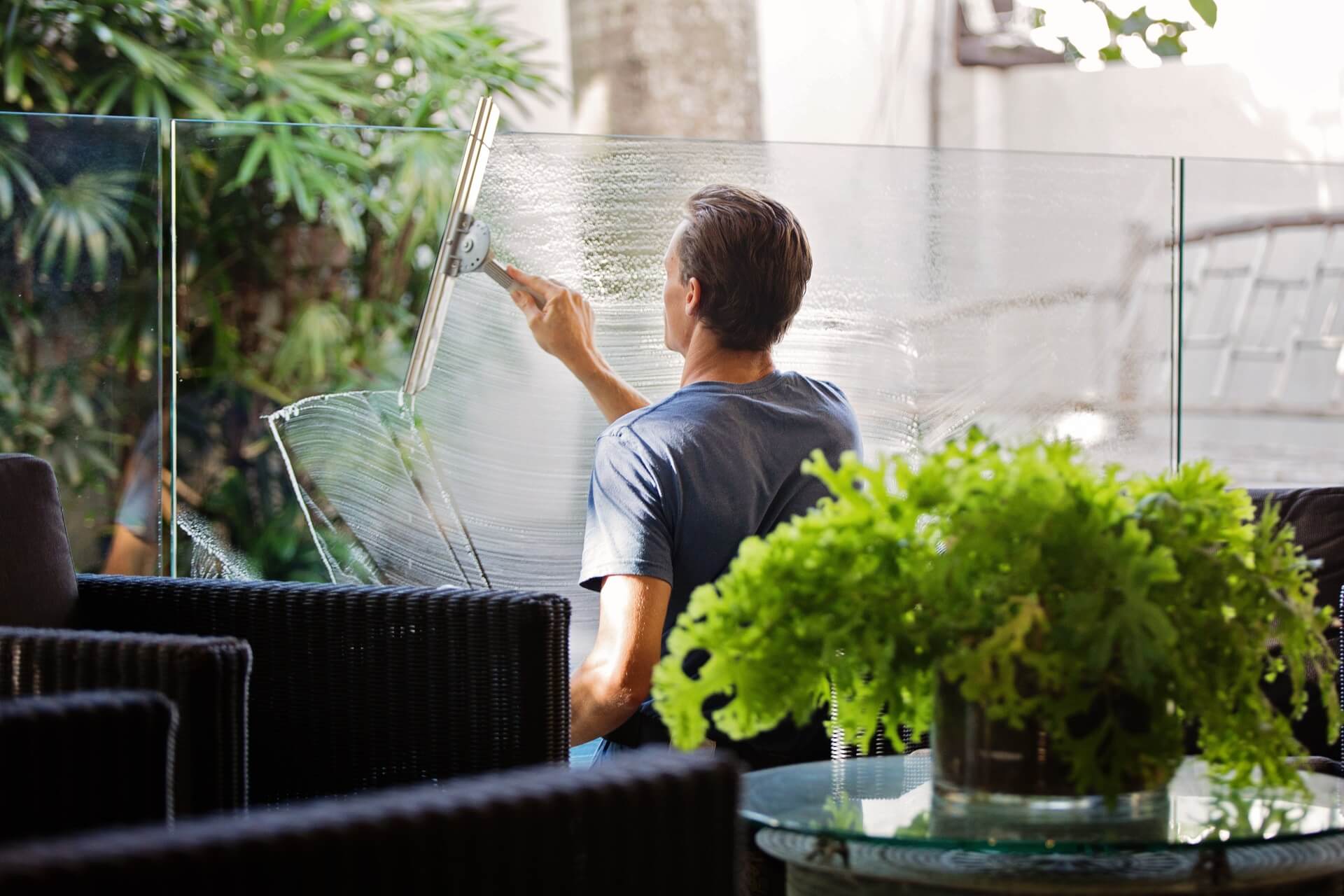 man cleaning the windows in an enlosed area